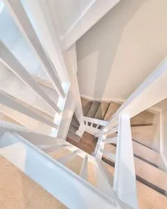 1a7cab7f40d6767dfca35aa8e457ce3b.double-winder-staircase-painted-white-with-carpeted-stairs-top-shot-through-middle (1)